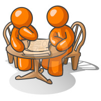 Two orange men at a wooden table pondering a problem together.